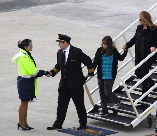 John Travola dans son uniforme de Captain à sa descente de son Boeing 707 privé