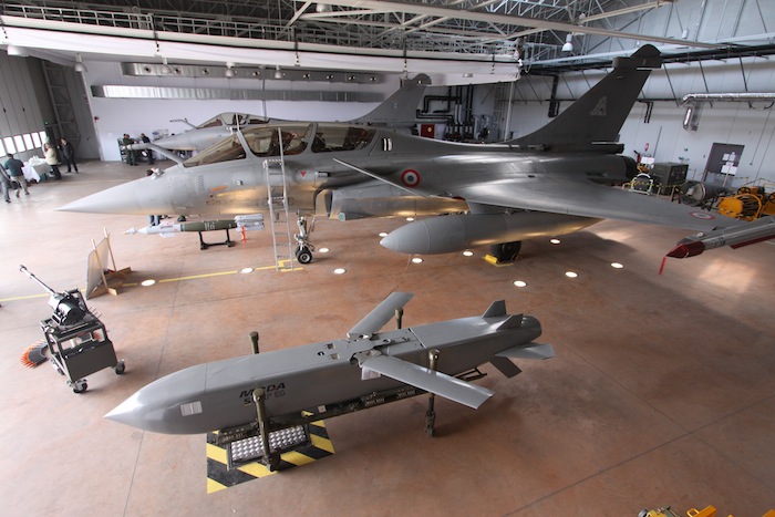 Missile SCALP-EG exposé devant un Rafale du CEAM de Mont-de-Marsan. La voilure, repliée quand le missile est accroché sous l'avion, est ici déployée comme pendant le vol